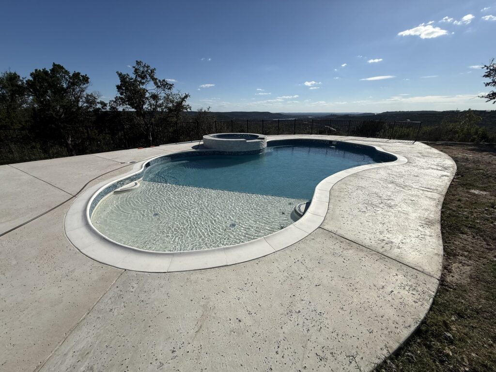 Custom freeform pool and raised spa in Leander, TX by Renaissance Pools