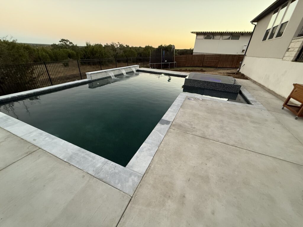 Custom pool and champagne spa with waterfall wall in Dripping Springs, TX