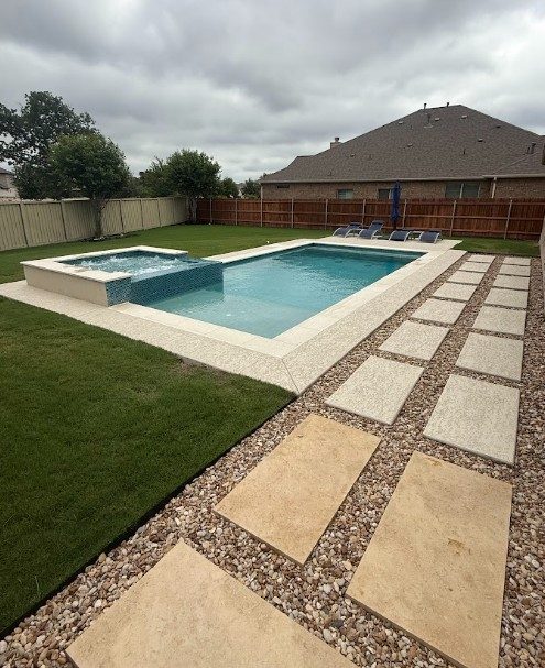Custom pool with offset raised spa and tanning ledge in Leander, TX