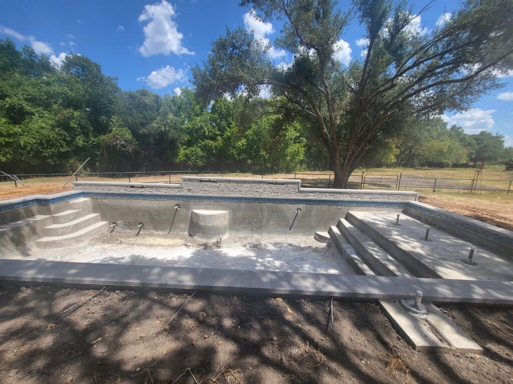 Custom pool with raised waterfall wall in Leander, TX by Renaissance Pools