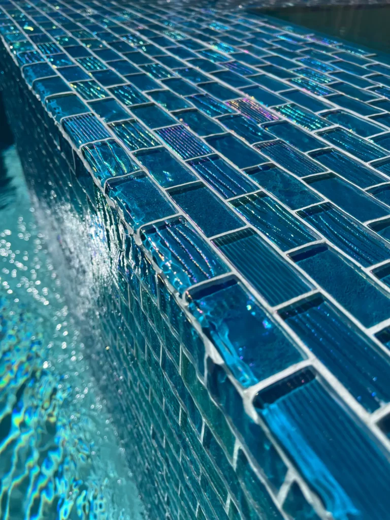 Blue glass waterline tile on a custom pool in Austin