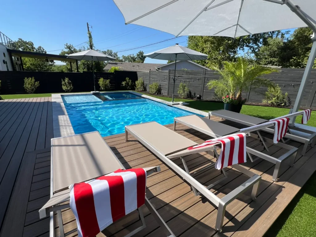Modern rectangular pool with wood deck and loungers in Austin