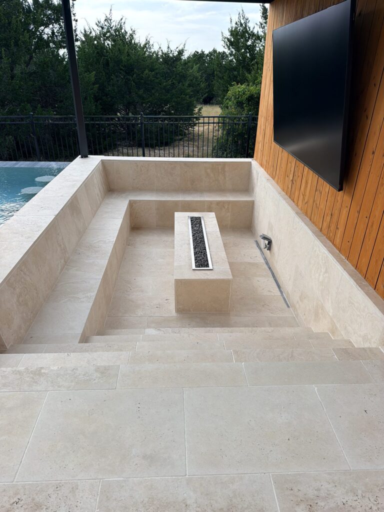 Sunken fire pit, pergola and outdoor TV wall in Dripping Springs, TX