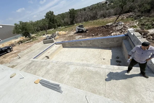Pool shell under construction with crew on site