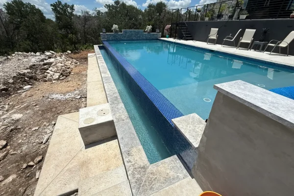 Pool with glass tile water wall during construction